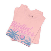 Ridin' Waves Pink Graphic Tee with coastal cowgirl design, featuring retro surfboard and palm trees on soft 100% cotton fabric.