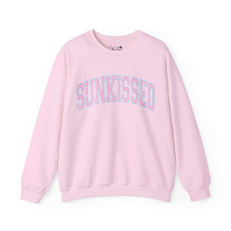 Light pink crewneck sweatshirt with "Sunkissed" text in varsity font, made from cotton and polyester blend, featuring long sleeves.